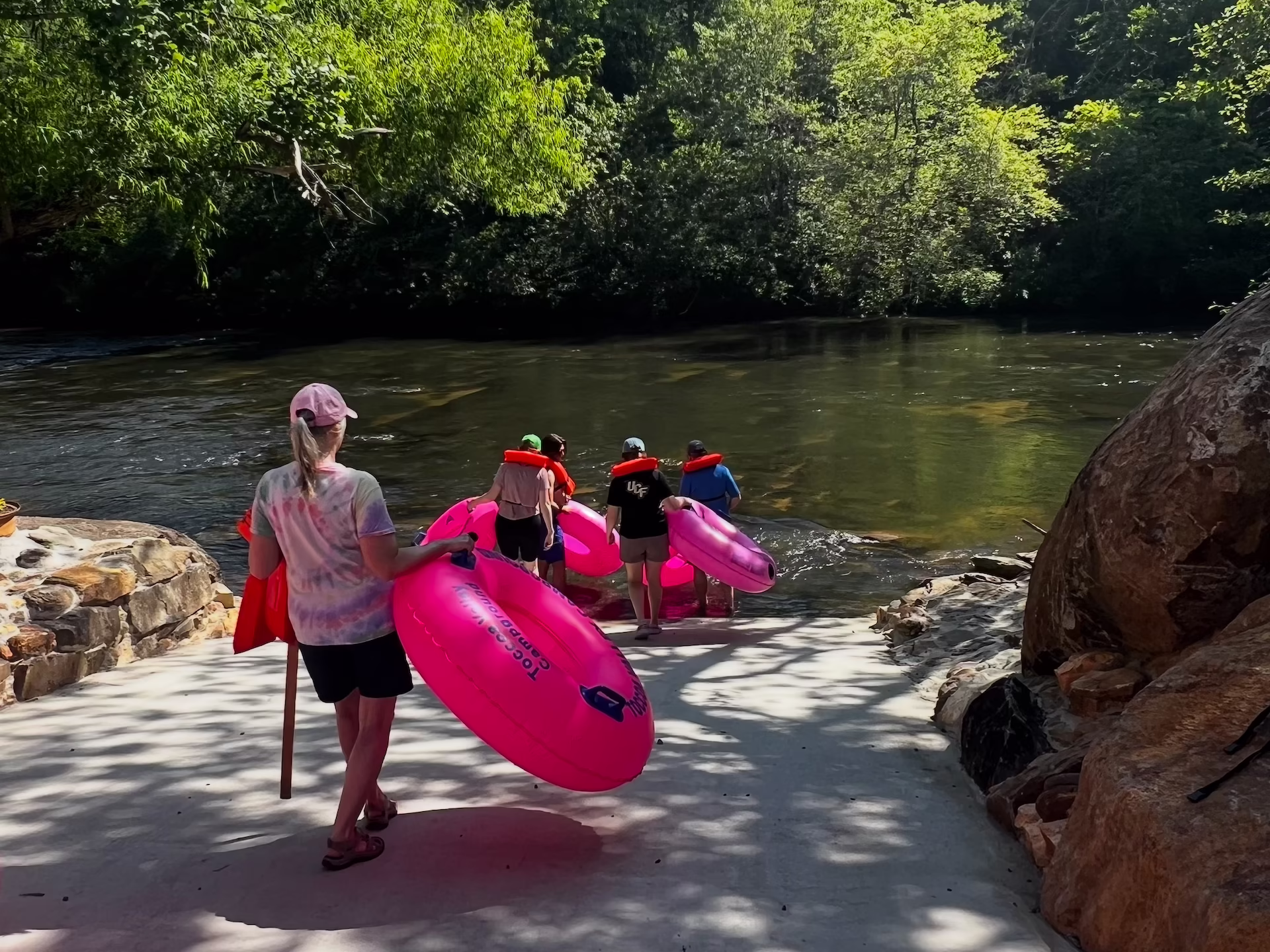 IMG_3225 People with tubes walking down a ramp into the river.